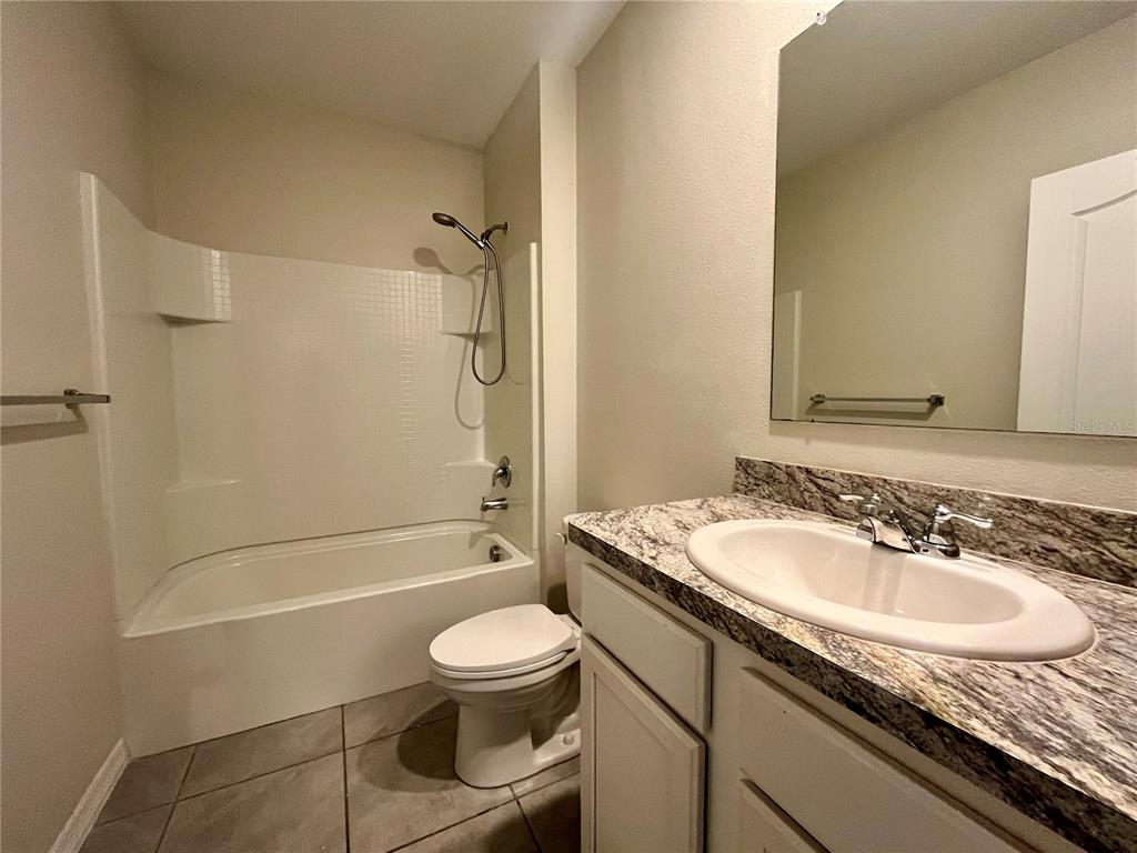 531 Auburn Grove Terrace Auburndale, FL 33823 - Photo 20 of 26 a bathroom with a granite countertop sink toilet and shower