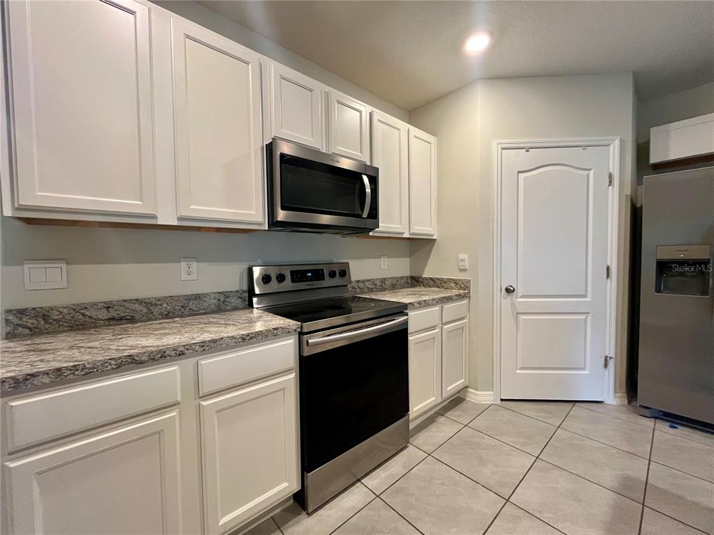 531 Auburn Grove Terrace Auburndale, FL 33823 - Photo 8 of 26 a kitchen with granite countertop white cabinets and stainless steel appliances