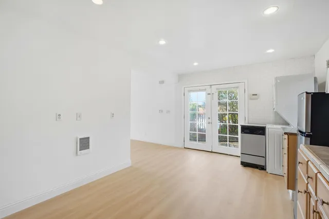 an empty room with furniture and a flat screen tv