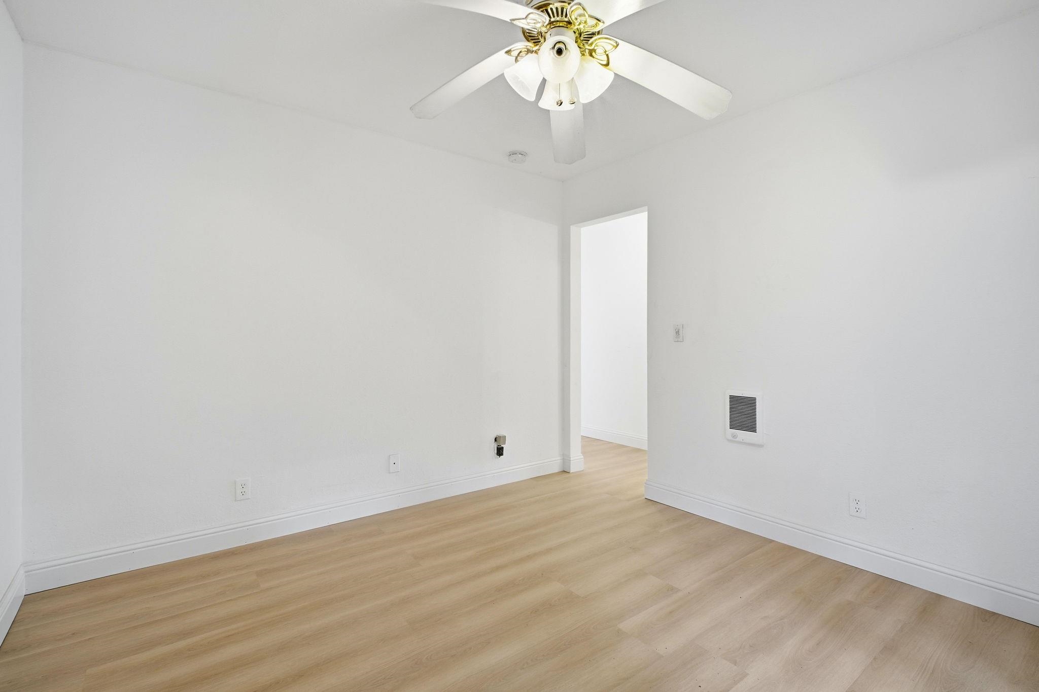 14683 Midland Road San Leandro, CA 94578 - Photo 20 of 31 an empty room with a chandelier fan and wooden floor