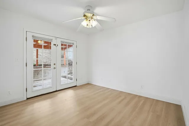 an empty room with windows and fan