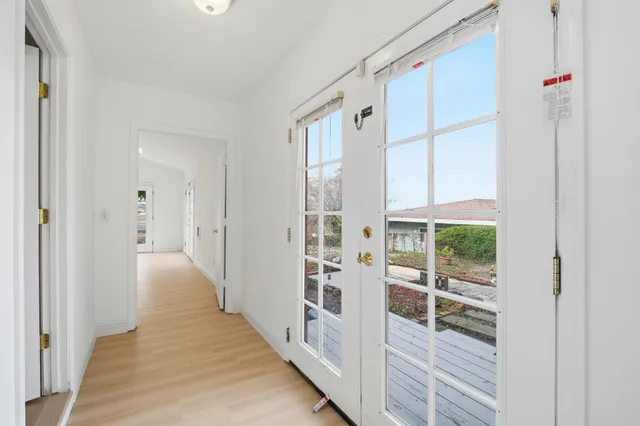 a view of a hallway with wooden floor and entryway