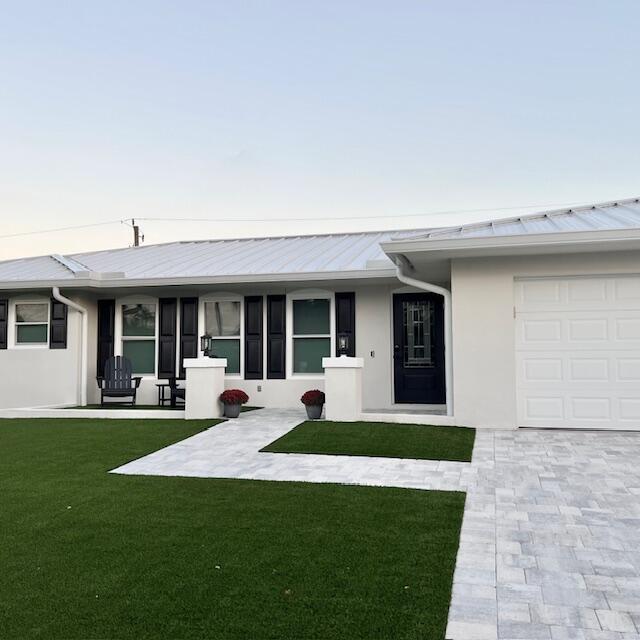 11 Southeast Splitrail Circle Jupiter, FL 33469 - Photo 2 of 48 a front view of a house with a yard and porch
