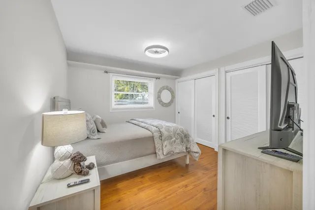 a bedroom with a bed and a flat tv screen on dresser