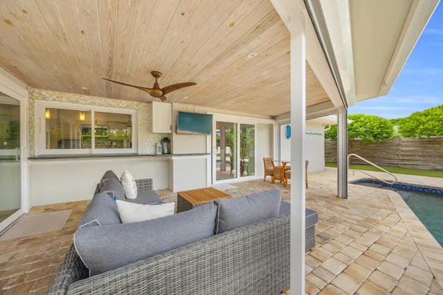 a view of swimming pool with lounge chair and dinning table under an umbrella