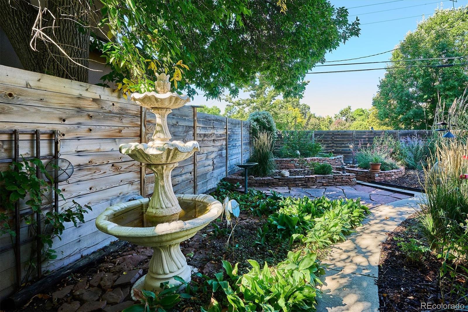 2363 South Adams Street Denver, CO 80210 - Photo 38 of 50 a view of a backyard with table and chairs potted plants and a fountain