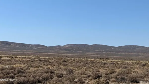 a view of mountain and grassy field