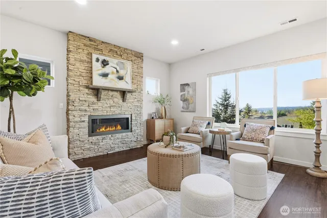 a living room with furniture a large window and a fireplace