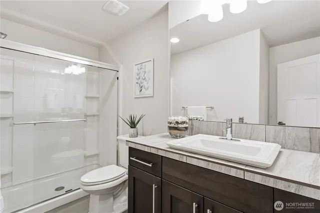 a bathroom with a sink a toilet and shower