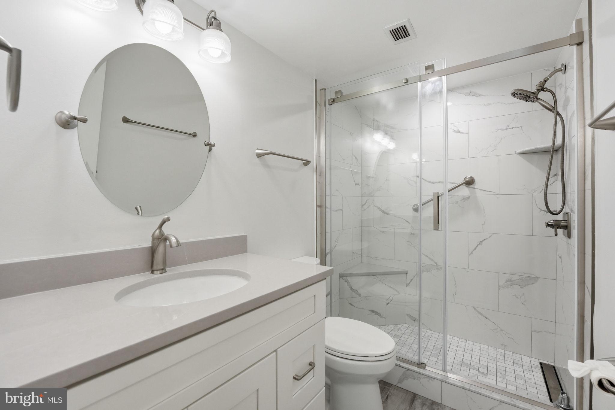 2817 Jermantown Road, Unit 107 Oakton, VA 22124 - Photo 13 of 28 a bathroom with a granite countertop sink a toilet and shower