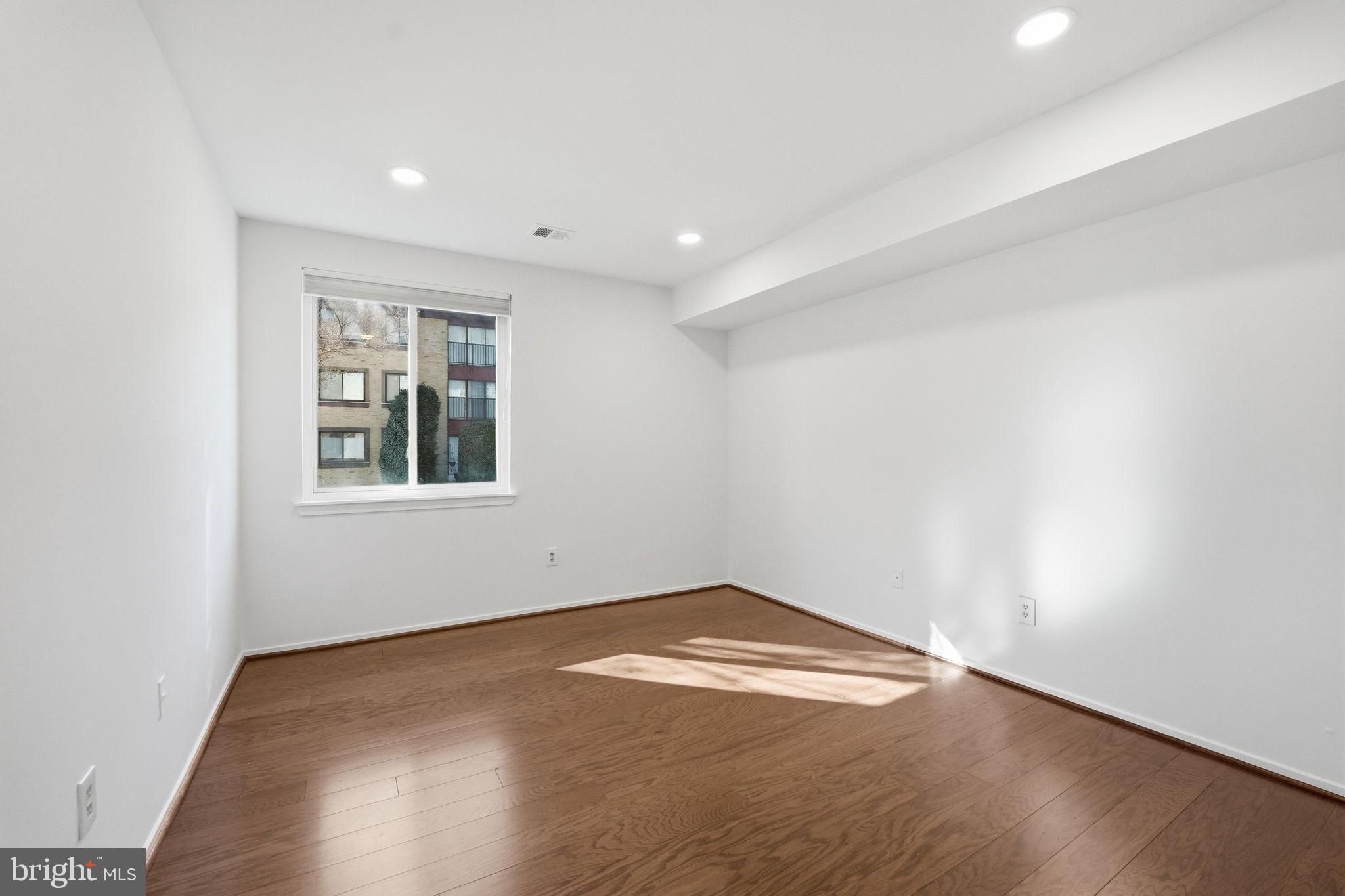 2817 Jermantown Road, Unit 107 Oakton, VA 22124 - Photo 15 of 28 an empty room with wooden floor and windows