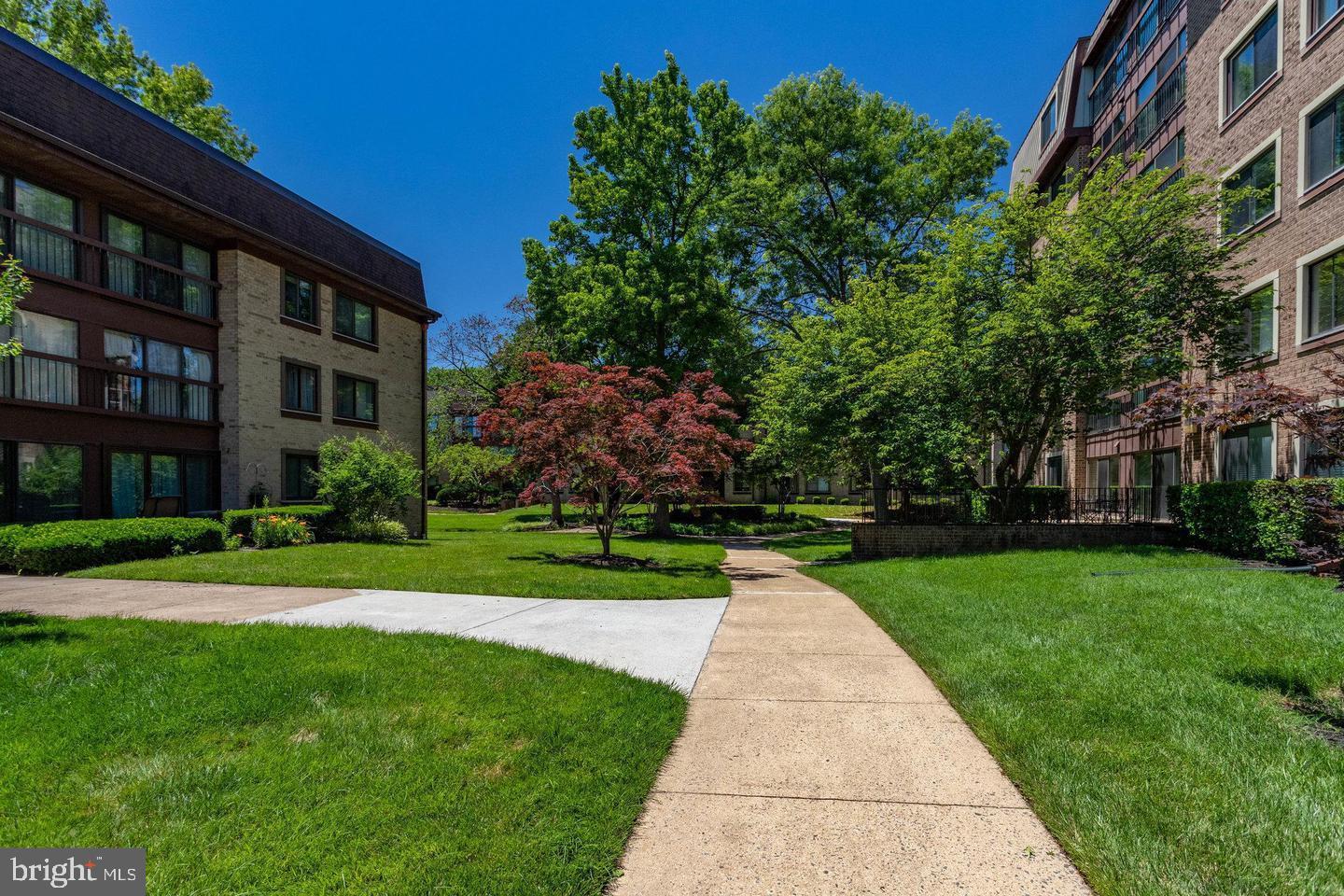 2817 Jermantown Road, Unit 107 Oakton, VA 22124 - Photo 20 of 28 a view of a brick building next to a big yard