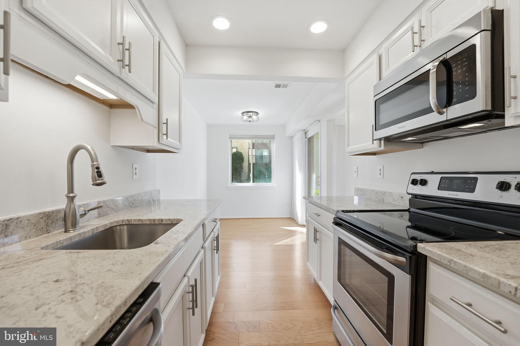 2817 Jermantown Road, Unit 107 Oakton, VA 22124 - Photo 2 of 28 a kitchen with stainless steel appliances granite countertop a sink and a stove