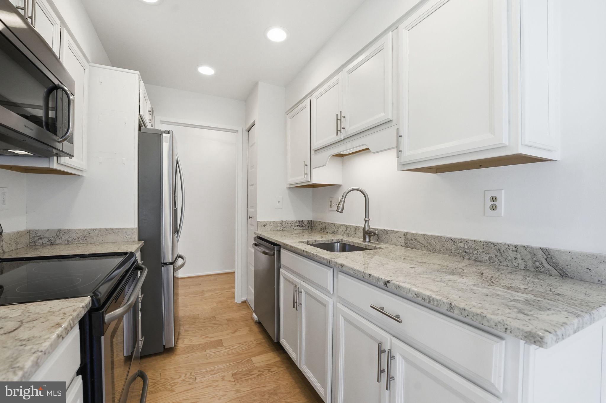 2817 Jermantown Road, Unit 107 Oakton, VA 22124 - Photo 4 of 28 a kitchen with stainless steel appliances granite countertop a sink stove and refrigerator