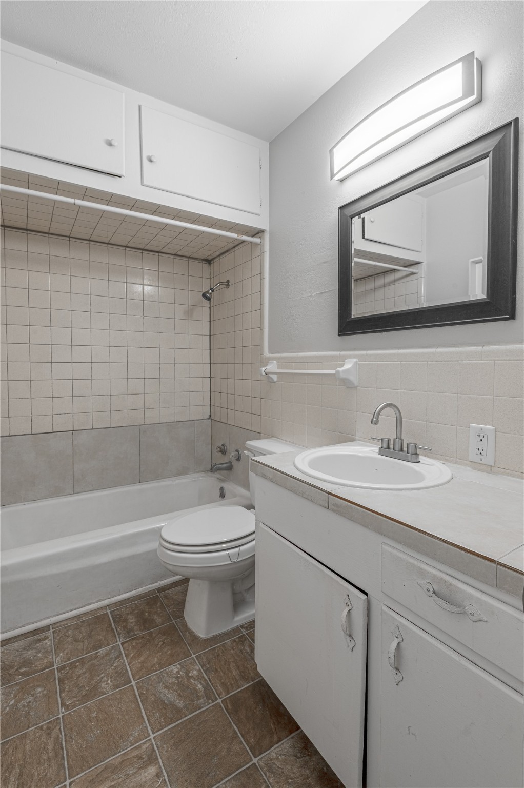 525 12th Street, Unit 7 Huntsville, TX 77340 - Photo 14 of 21 a bathroom with a granite countertop toilet a sink a mirror and bathtub