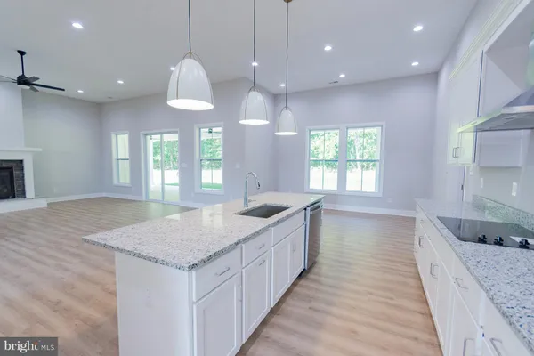 a kitchen with granite countertop a sink a counter top space and stainless steel appliances