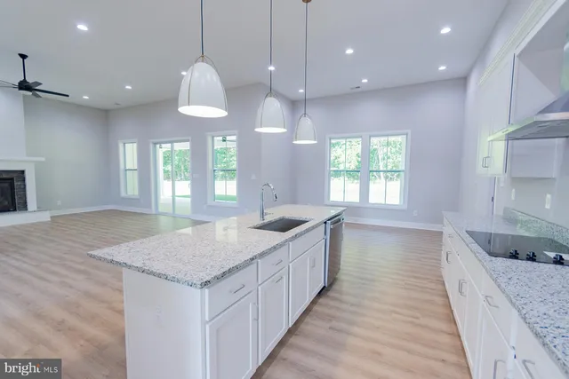 a kitchen with granite countertop a sink a counter top space and stainless steel appliances