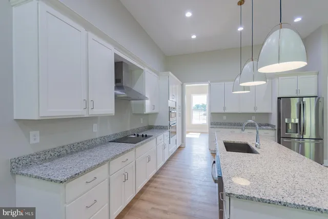 a kitchen with stainless steel appliances granite countertop a sink a stove and a refrigerator