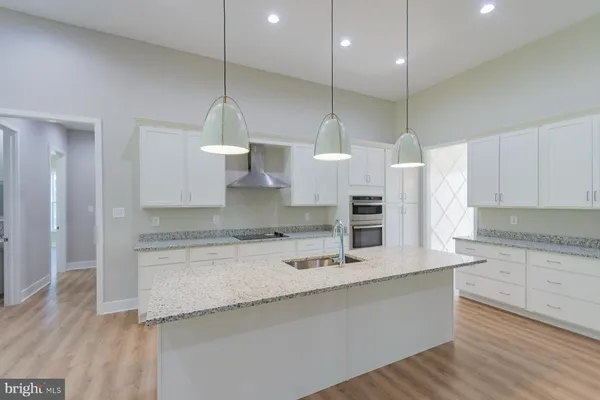 a kitchen with granite countertop white cabinets and stainless steel appliances