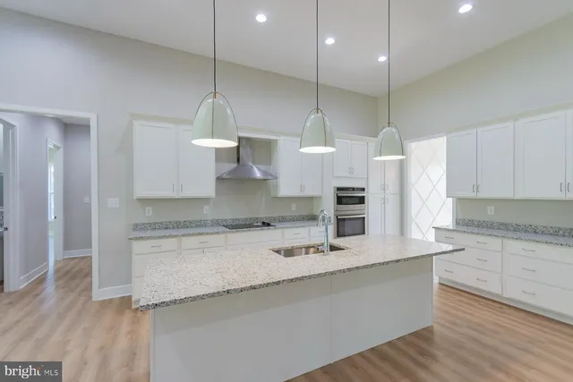 a kitchen with granite countertop white cabinets and stainless steel appliances