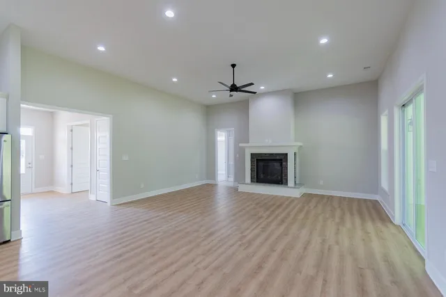 a view of a kitchen with a sink and dishwasher a refrigerator with wooden floor