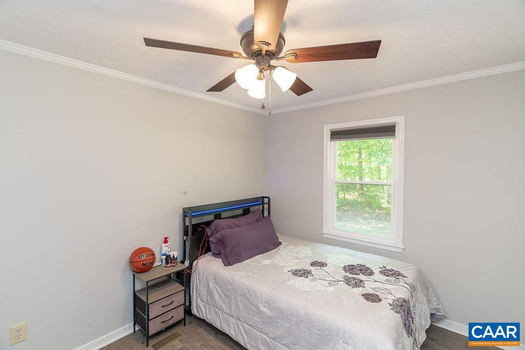 6920 Albevanna Spring Road Scottsville, VA 24590 - Photo 21 of 47 a bedroom with a bed and a chandelier