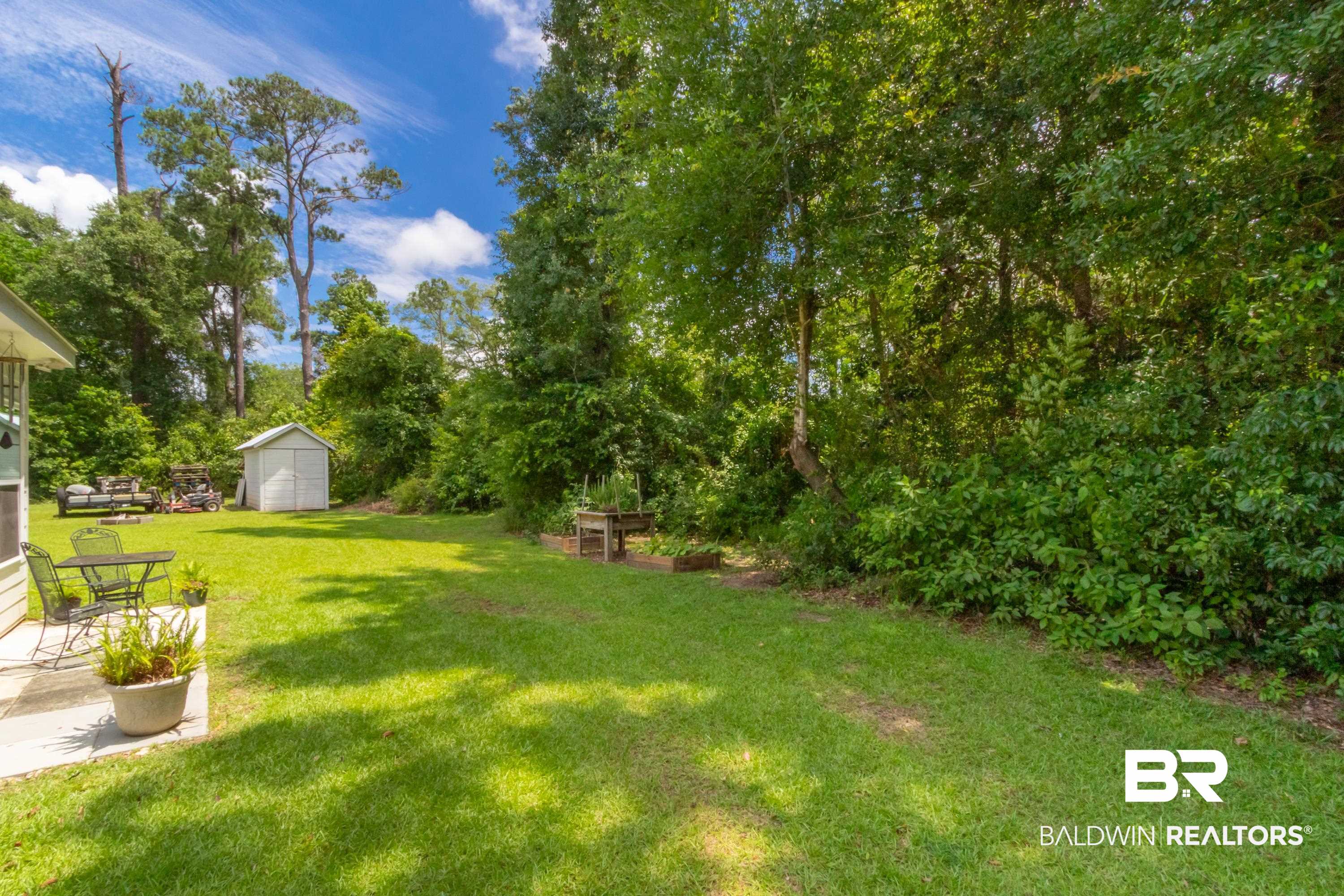 7472 Coopers Landing Road Foley, AL 36535 - Photo 37 of 40 Expansive grassy backyard featuring a white storage shed and mature perimeter trees