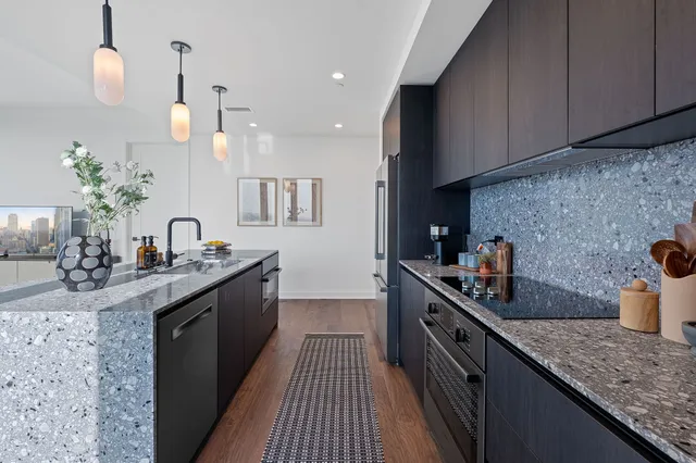 a kitchen with granite countertop a sink stove and cabinets