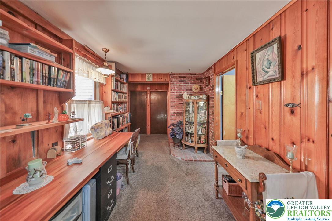 331 Cranberry Creek Road Cresco, PA 18326 - Photo 21 of 95 This cozy room offers built-in shelving, rich wood paneling, and a convenient desk area perfect for work or study.