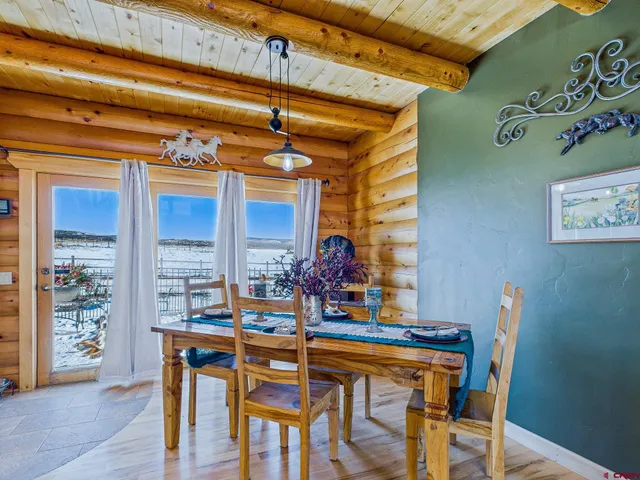 a kitchen with stainless steel appliances granite countertop a table chairs and a wooden cabinets