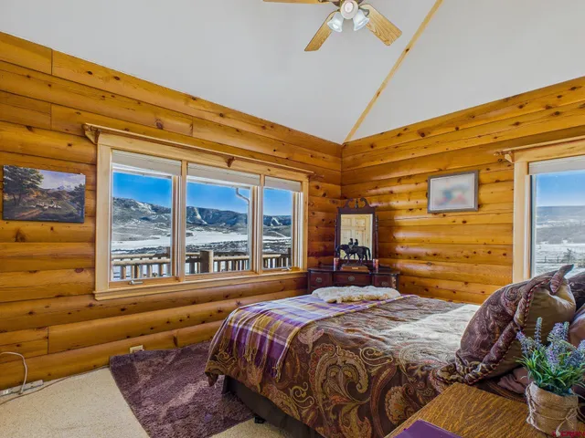 a bedroom with a bed and a large window