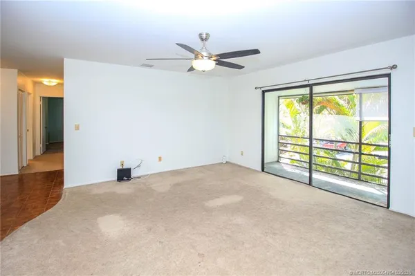 a view of a livingroom with a ceiling fan and window