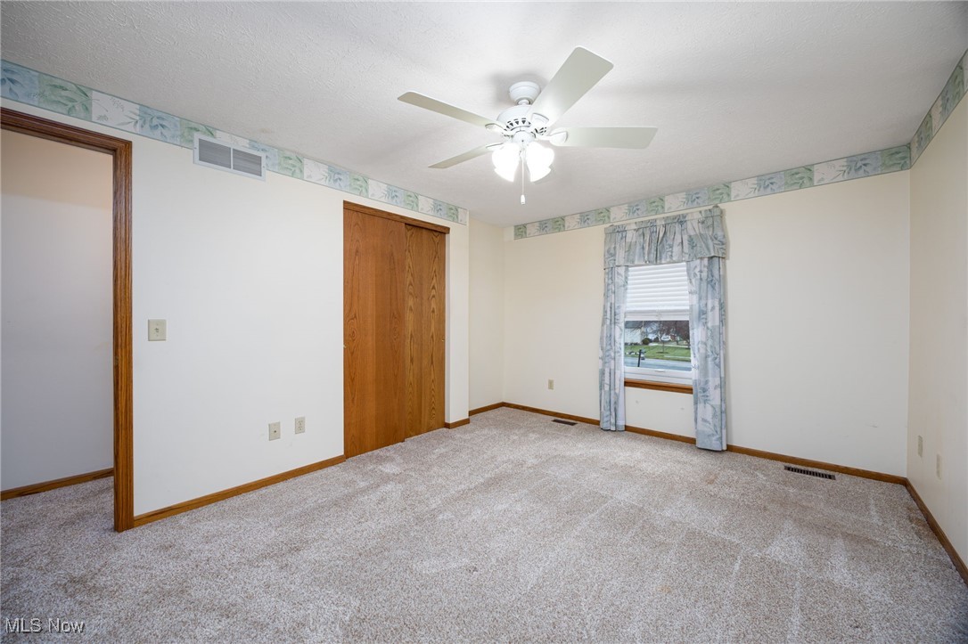 1838 Sandy Lake Road Ravenna, OH 44266 - Photo 34 of 41 Unfurnished bedroom featuring a closet, ceiling fan, and light carpet