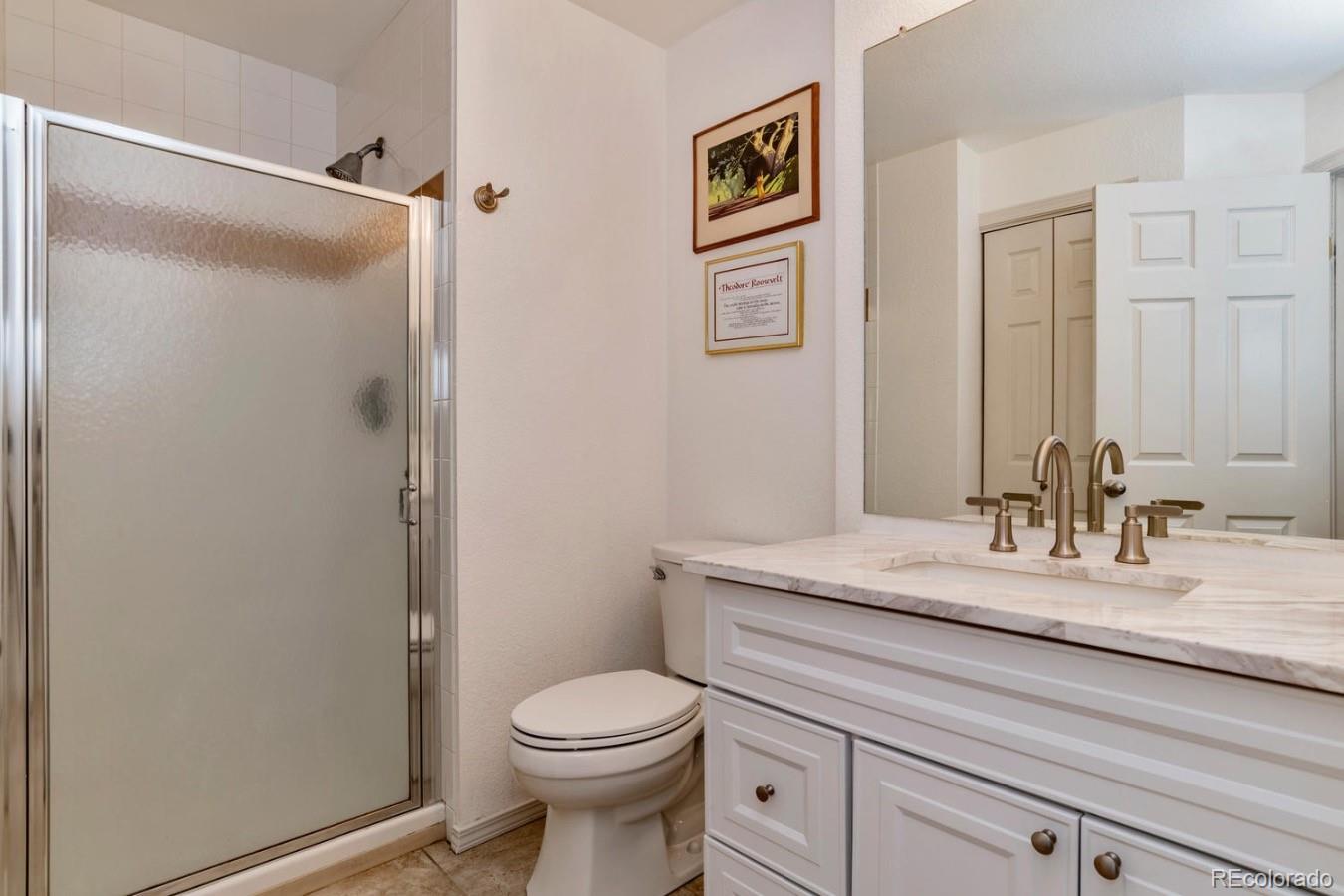 6486 Silver Mesa Drive, Unit B Highlands Ranch, CO 80130 - Photo 14 of 29 a bathroom with a granite countertop sink mirror vanity and toilet