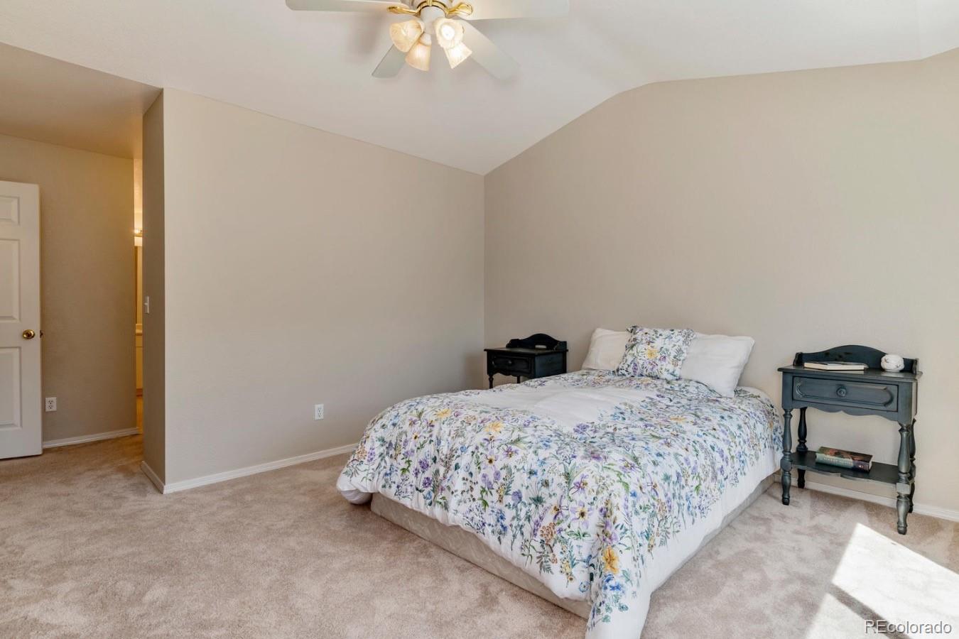 6486 Silver Mesa Drive, Unit B Highlands Ranch, CO 80130 - Photo 16 of 29 a bedroom with a bed and a chandelier