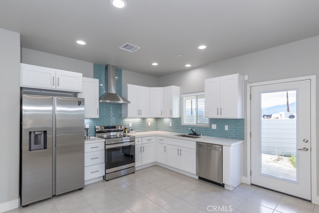 a kitchen with stainless steel appliances kitchen island granite countertop a refrigerator sink and stove