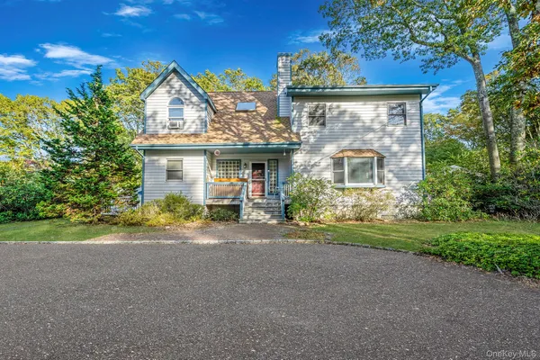 a view of a house with a yard and large tree