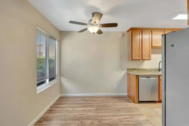 a view of an empty room with window and wooden floor