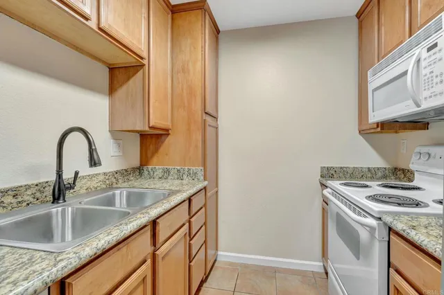 a kitchen with granite countertop a sink and a stove top oven
