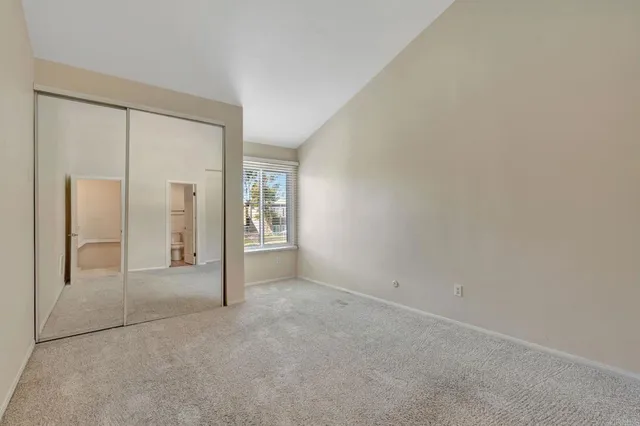 an empty room with closet and mirror