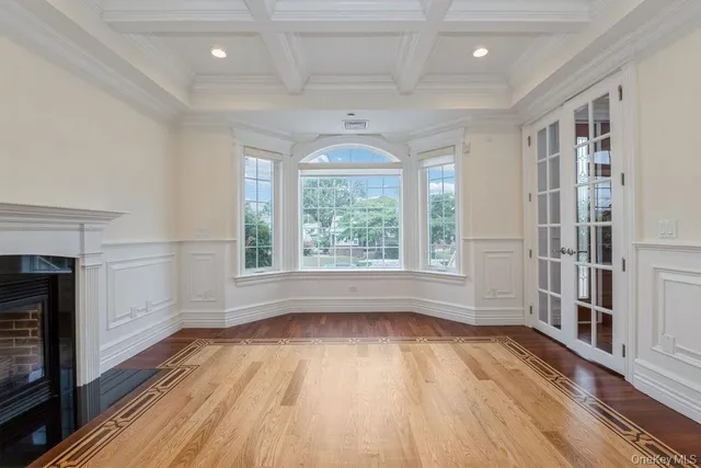 an empty room with windows and a fireplace