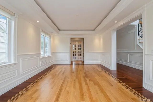 a view of an empty room with wooden floor and window