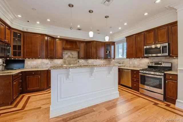 a large kitchen with stainless steel appliances kitchen island granite countertop a large counter top and oven