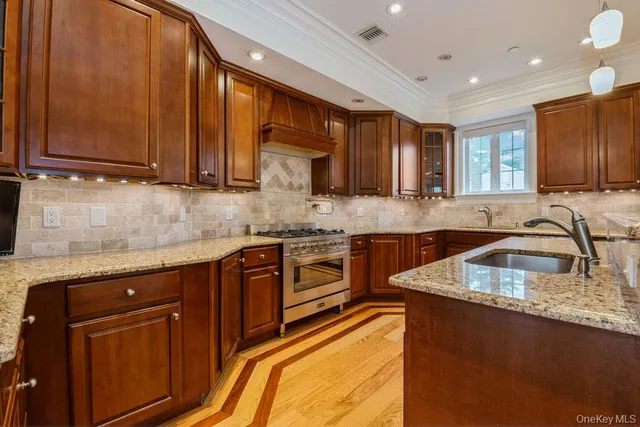 a kitchen with stainless steel appliances granite countertop wooden cabinets a stove top oven a sink and dishwasher