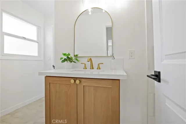 a bathroom with a sink a mirror and a window