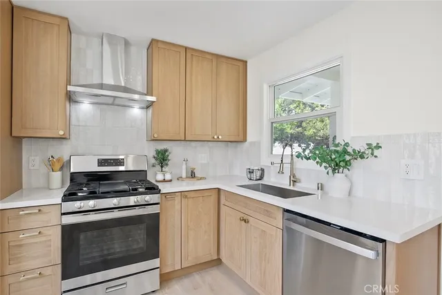 a kitchen with stainless steel appliances white cabinets and a stove top oven
