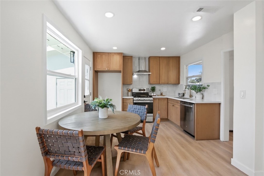 12262 Morrie Lane Garden Grove, CA 92840 - Photo 4 of 16 a kitchen with a table chairs sink and cabinets