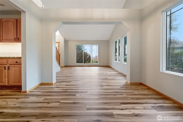 a view of a hallway with wooden floor and a living room