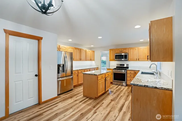 a kitchen with stainless steel appliances granite countertop a refrigerator stove microwave and sink
