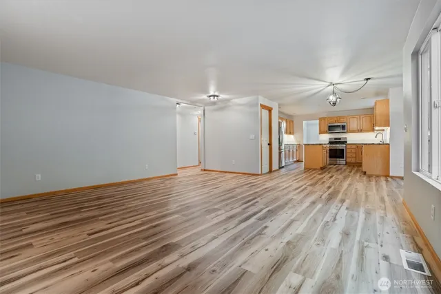 a view of empty room with wooden floor